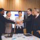 People during an M&A deal shaking hands and smiling because they have learned ho0w to navigate Indemnity Deductibles and Caps successfully.