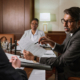 A lawyer walking a client through choosing the right business structure, going over forms at a desk.