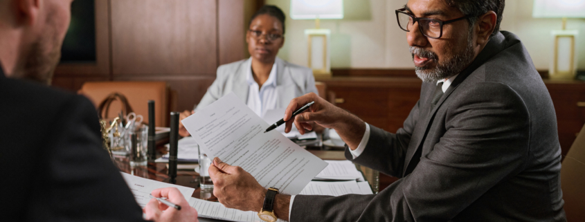 A lawyer walking a client through choosing the right business structure, going over forms at a desk.